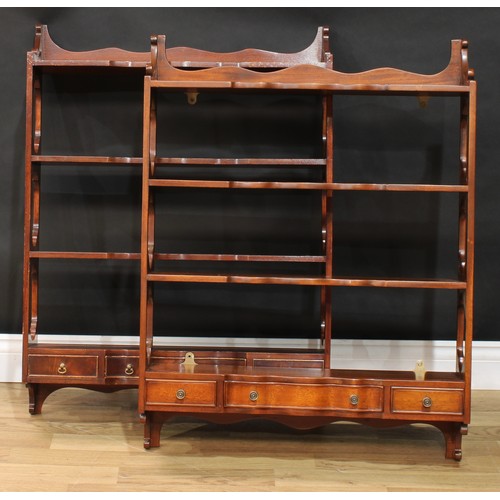 117 - A near pair of mahogany wall shelves, each with three shaped serpentine front shelves above three dr... 