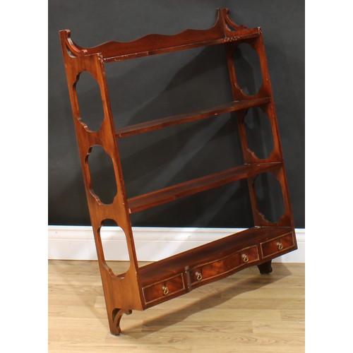 117 - A near pair of mahogany wall shelves, each with three shaped serpentine front shelves above three dr... 