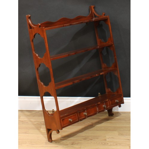 117 - A near pair of mahogany wall shelves, each with three shaped serpentine front shelves above three dr... 