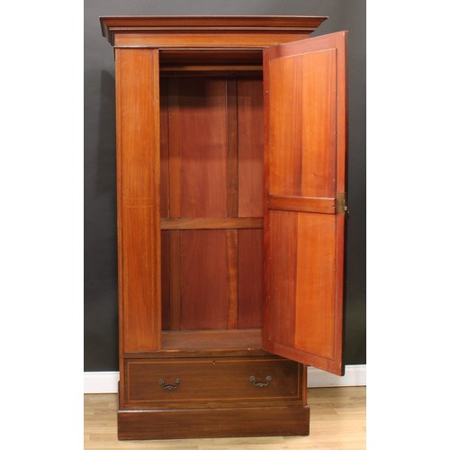120 - An Edwardian mahogany wardrobe, outswept cornice with faux-dentil parquetry apron above an oval beve... 