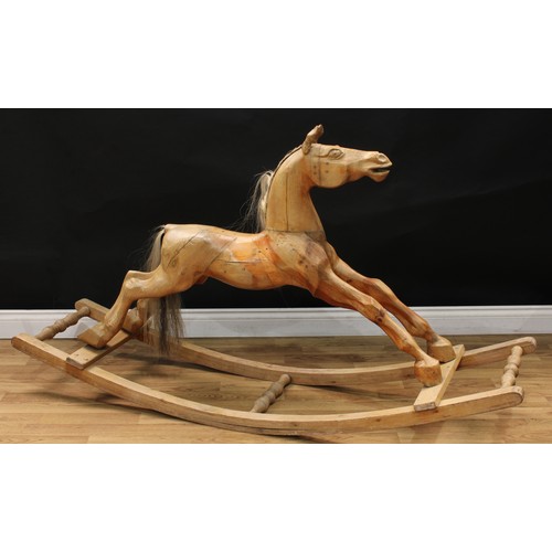 2232 - An early 20th century carved wooden bow rocking horse, the stripped and deeply carved horse with pri... 