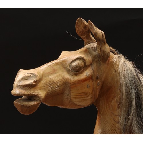 2232 - An early 20th century carved wooden bow rocking horse, the stripped and deeply carved horse with pri... 