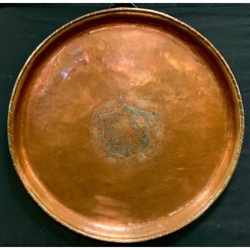 145 - An arts and crafts Hugh Wallis hand crafted copper charger with central lion rampant shield 57cm dia... 