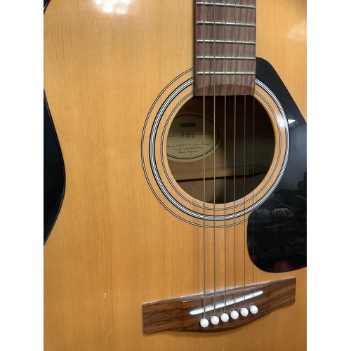 205 - A Yamaha F-310 six string acoustic guitar;  Mahalo U30G red Ukulele;  a childs Palma PJROFT guitar, ... 