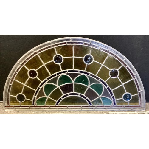 189 - An early 20th century arched stained glass window, floral crest beneath amber and blue top, 98cm wid... 