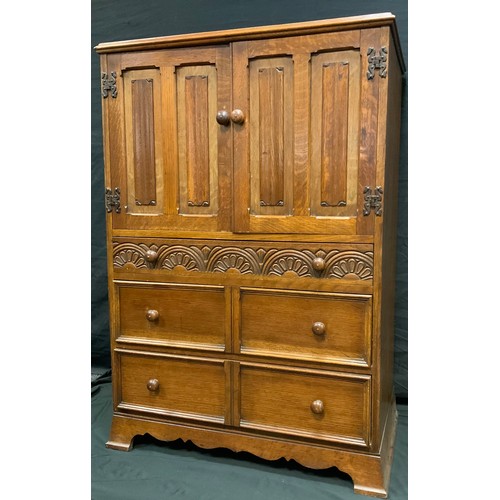 268 - A mid 20th century oak tall boy, pair of linen fold doors over three graduated drawers, Arts & Craft... 