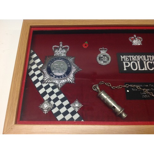 202 - Framed display of Metropolitan Police badges to include two helmet plates (Both Queens Crown) , two ... 