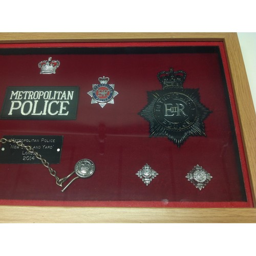 202 - Framed display of Metropolitan Police badges to include two helmet plates (Both Queens Crown) , two ... 