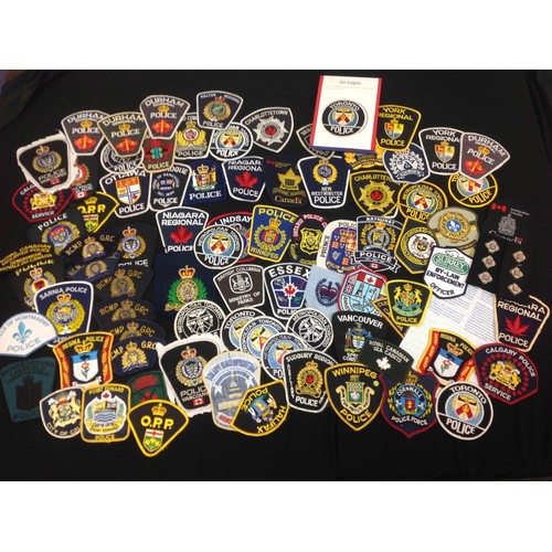 213 - A large collection of Royal Canadian Mounted Police insignia and Canadian Police Dept shoulder sleev... 