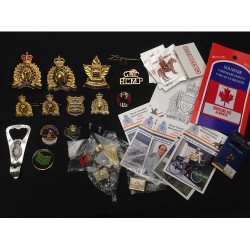 213 - A large collection of Royal Canadian Mounted Police insignia and Canadian Police Dept shoulder sleev... 