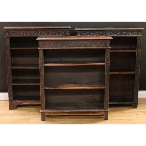 111 - A late Victorian ebonised oak open bookcase, carved with scrolling acanthus and floral lunettes, 114... 