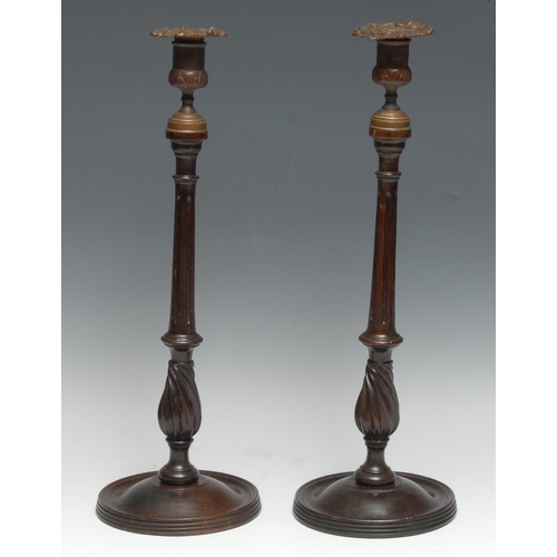 3218 - A pair of 19th century mahogany table candlesticks, cast brass campana sconces, fluted pillars, wryt... 