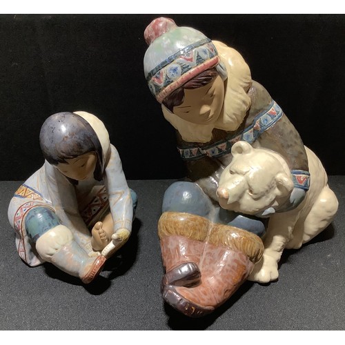 76 - A large Lladro figure of a boy and polar bear, 24cm high;  another of an Inuit (2)