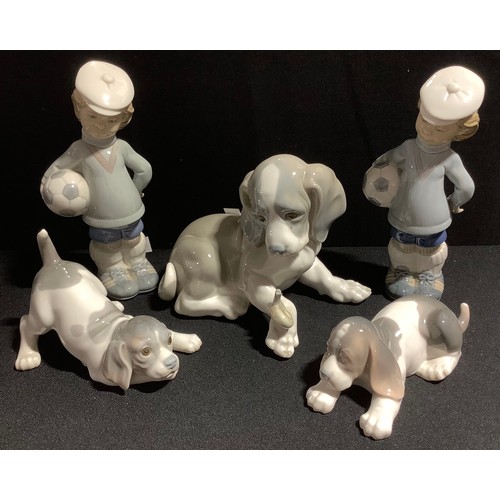 78 - A large Lladro figure of a puppy, 15cm high; others; two Lladro figures of boy and football (5)