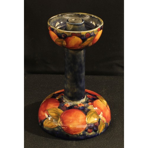 89 - A Moorcroft Pomegranate pattern candlestick21cm high, impressed mark, paper label (faults)