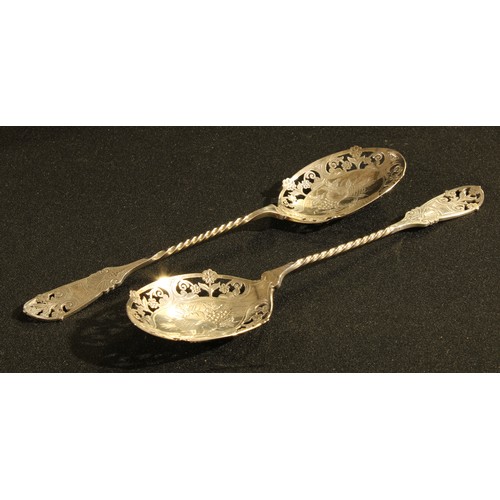 94 - A pair of Victorian silver pierced fruit spoons, the bowls engraved with pineapple, peaches and grap... 