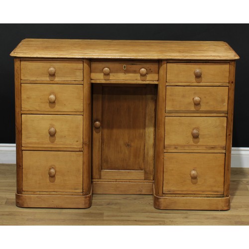 601 - A pine kneehole desk, rectangular top with moulded edge above an arrangement of nine short drawers, ... 