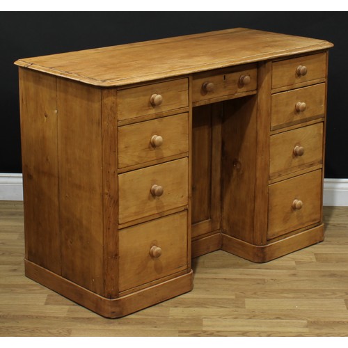 601 - A pine kneehole desk, rectangular top with moulded edge above an arrangement of nine short drawers, ... 