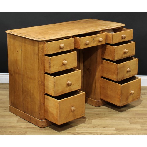 601 - A pine kneehole desk, rectangular top with moulded edge above an arrangement of nine short drawers, ... 