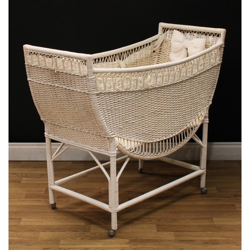 619 - A white painted wicker baby doll crib or cot, 92cm high, 107cm long, 50cm wide