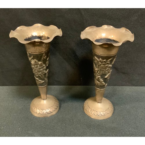 396 - A pair of Indian silver coloured metal trumpet shaped vases, hand embossed with flowering foliage, c... 