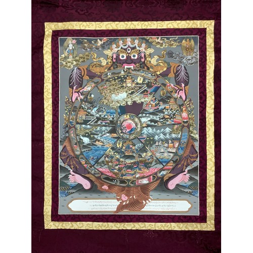 635 - A Tibetan wall hanging scroll, central panel with Thangka Wheel of Life, approximately 130cm x 85cm