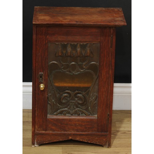 120A - An Art Nouveau oak wall hanging cabinet, copper fretwork overlaid glazed door enclosing two shelves;... 