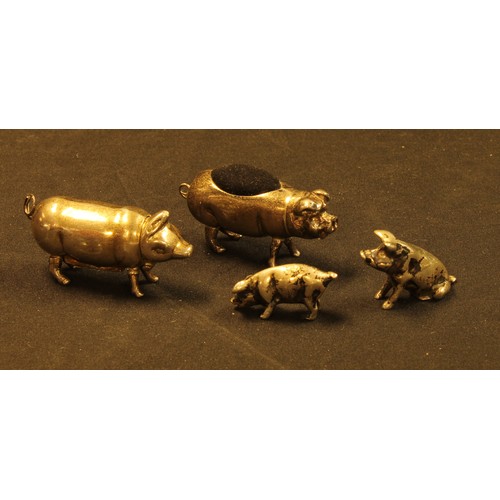 651 - A pair of novelty silver coloured metal pigs, marked 925;  a novelty pig pin cushion;  a novelty pig... 