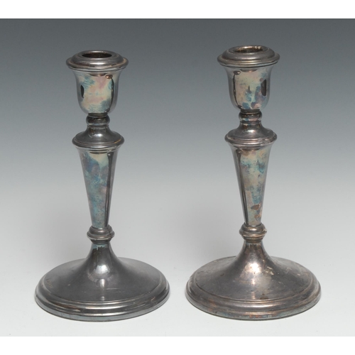 173 - A pair of Elizabeth II silver table candlesticks, urnular sconces, tapered pillars, spreading circul... 