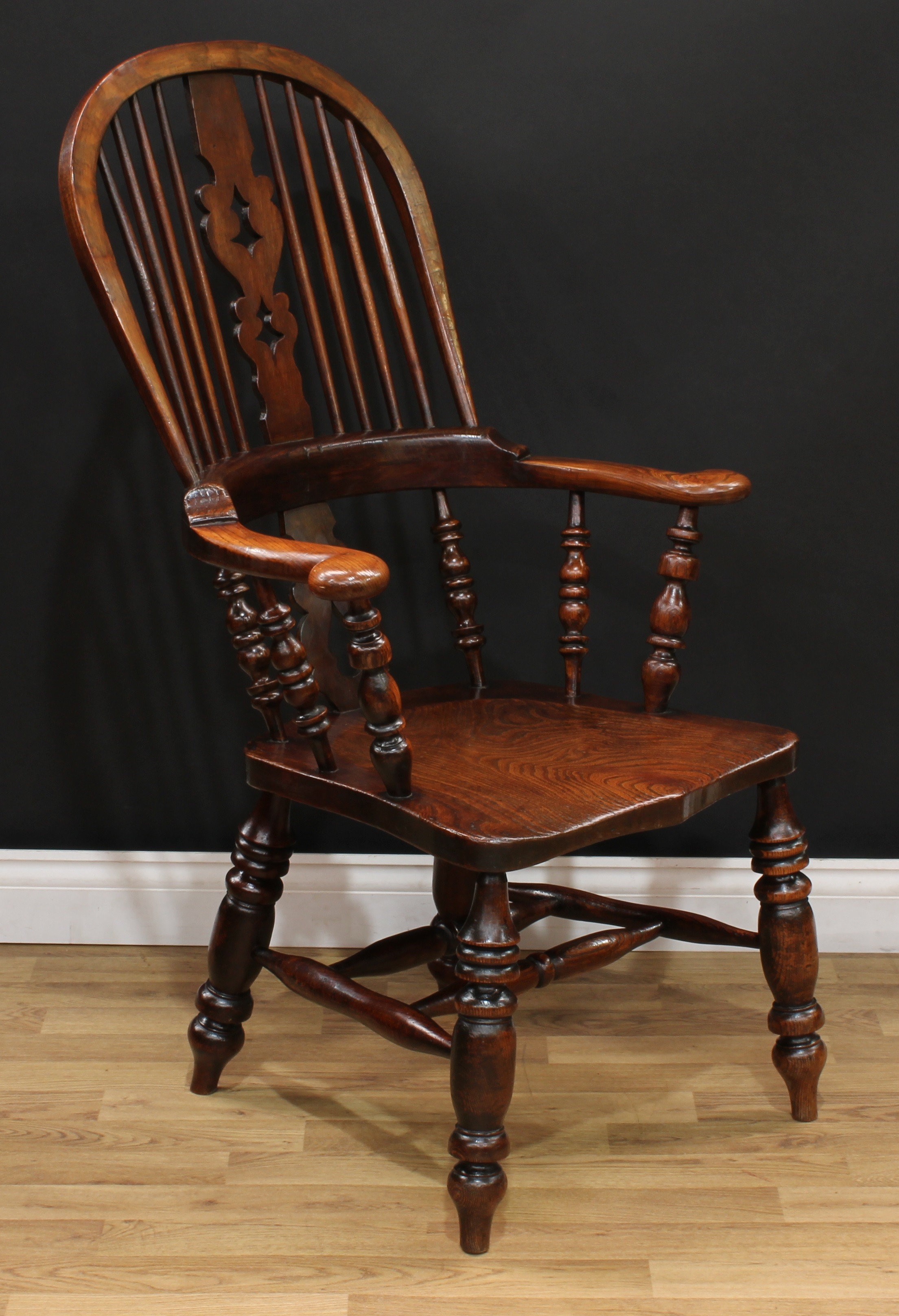 A 19th century elm Windsor elbow chair, hoop back, Christmas tree splat...