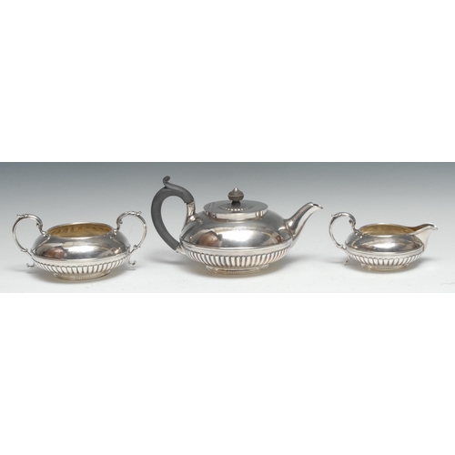 87 - A composed George IV and early Victorian silver three piece half-fluted compressed globular tea serv... 