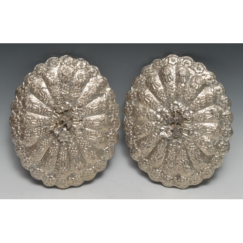 194 - A pair of Turkish silver shaped oval mirrors, chased with flowers and applied with peacocks, 22cm wi... 