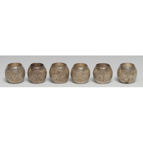 217 - A set of six Persian silver napkin rings, typically chased in the Islamic taste with dense stylised ... 