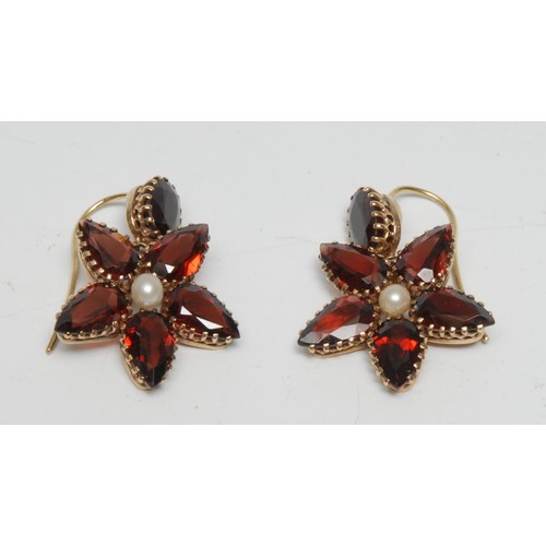 378 - A pair of amandine garnet and pearl star earrings, each with a central single pearl within five poin... 