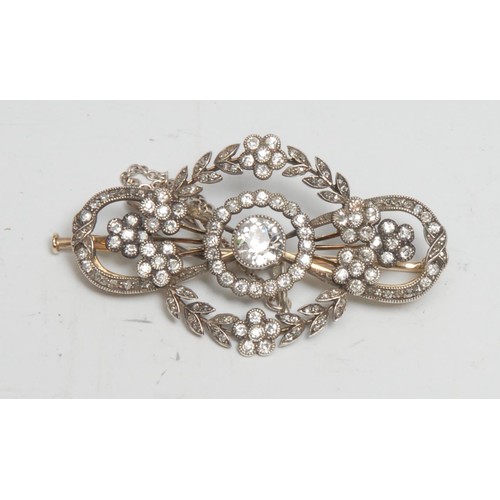 372 - A gold and platinum diamond brooch, the central stone approx 0.50ct surrounded by a garland of diamo... 