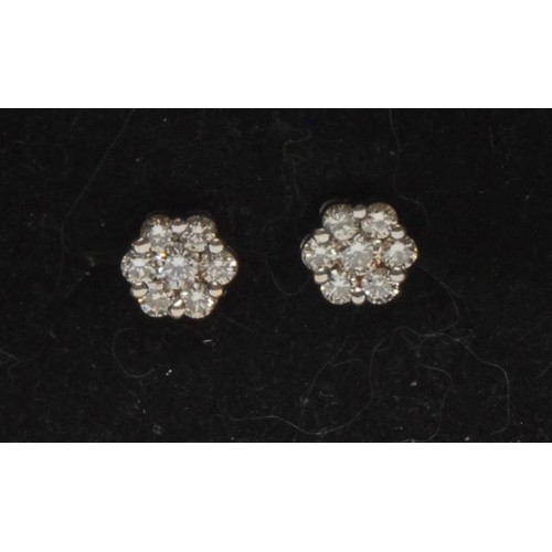 379 - A pair of diamond cluster earrings each set with seven round brilliant cut diamonds, total est diamo... 