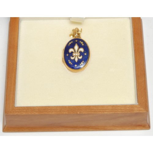 376 - A modern Faberge diamond inset 18ct gold royal blue and white enamelled oval locket, signed verso, 
... 