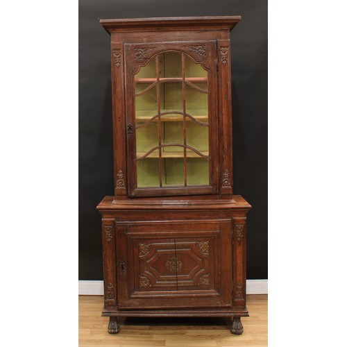 1976 - An 18th century Continental oak display cabinet, outswept cornice above an astragal glazed door encl... 