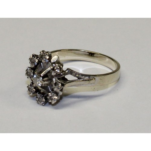 673 - An unmarked metal diamond cluster ring, the central stone surrounded by eight further illusion set d... 