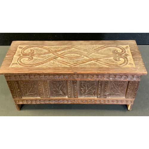 107 - Miniature Furniture  - a carved blanket box, scrolled plank top, leaf carved four panel front, stile... 