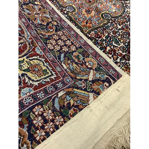 120 - A Persian Kashan type carpet, finely woven with an intricate central field, in red, green, and blue,... 