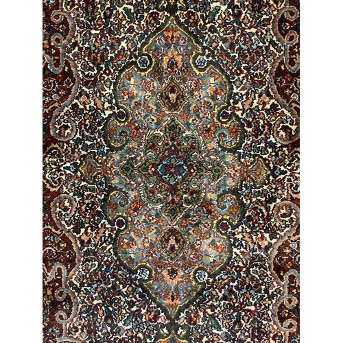 120 - A Persian Kashan type carpet, finely woven with an intricate central field, in red, green, and blue,... 