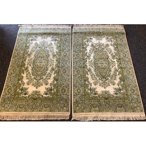 133 - A Pair of Persian Isfahan type Rugs, the wool pile and silk carpets in subdued shades of green and j... 