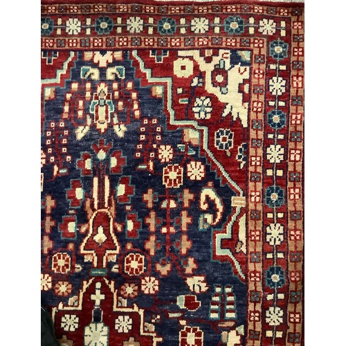 136 - A Hamadan carpet, central geometric medallion in tones of cream, bule and claret, 214cm x 127cm