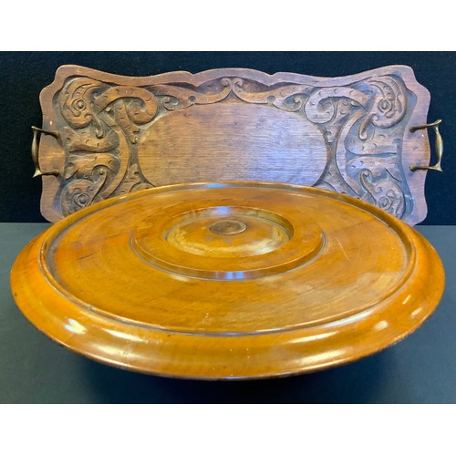 197 - A 20th century carved oak rectangular tray, brass handle, 60cm wide, 28cm deep; a mahogany revolving... 