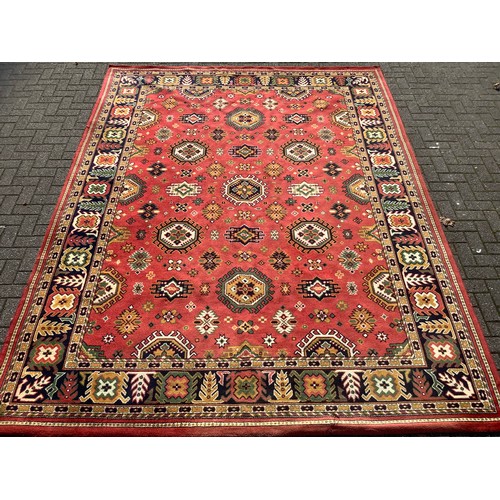 249 - A large Turkish Amara woollen carpet, all over decorated with geometric medallions, red ground, six ... 