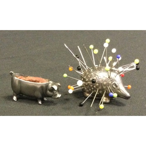 422 - A Novelty silver pin cushion as a Hedgehog, London 1898, 15g gross; a white metal pin cushion as a P... 