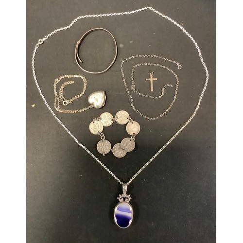 446 - A silver mounted oval pendant, set with an amethyst; a silver heart locket;  silver child's bangle; ... 