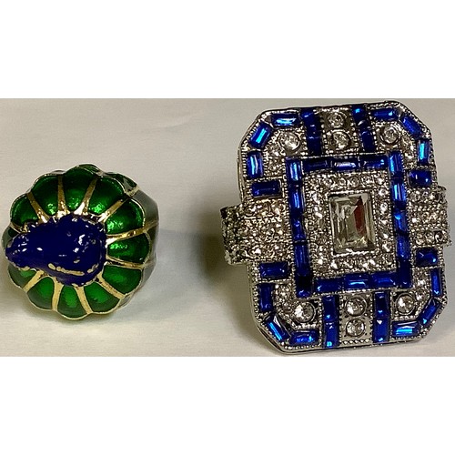 382 - A base metal dress ring, green and blue enamel, surmounted with a frog, size L and another large bas... 