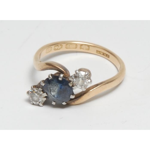 391 - A diamond and sapphire twist ring, central old cut mixed tone blue sapphire, approx 0.75ct, flanked ... 